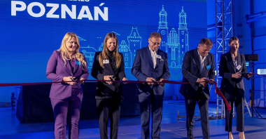 The photo shows representatives of SUUS Logistics, the mayor of Tarnów Podgórny and Head of the Investor Relations Department, Katja Lożina, during the grand opening of the company's warehouse. Individuals cut the red sash with scissors.
