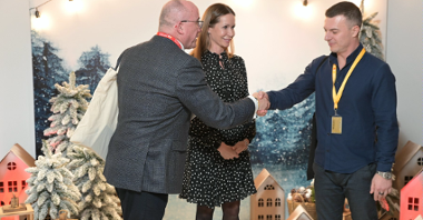 The photo shows SOFTSWISS founder Ivan Montik. He shakes hands with Maciej Wieczorek, regional director of SOFTSWISS. Standing next to him is Katja Lozina, director of the Investor Relations Department.
