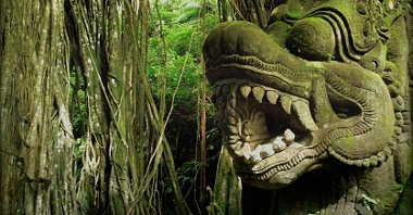 Photo of stone sculpture among exotic plants.